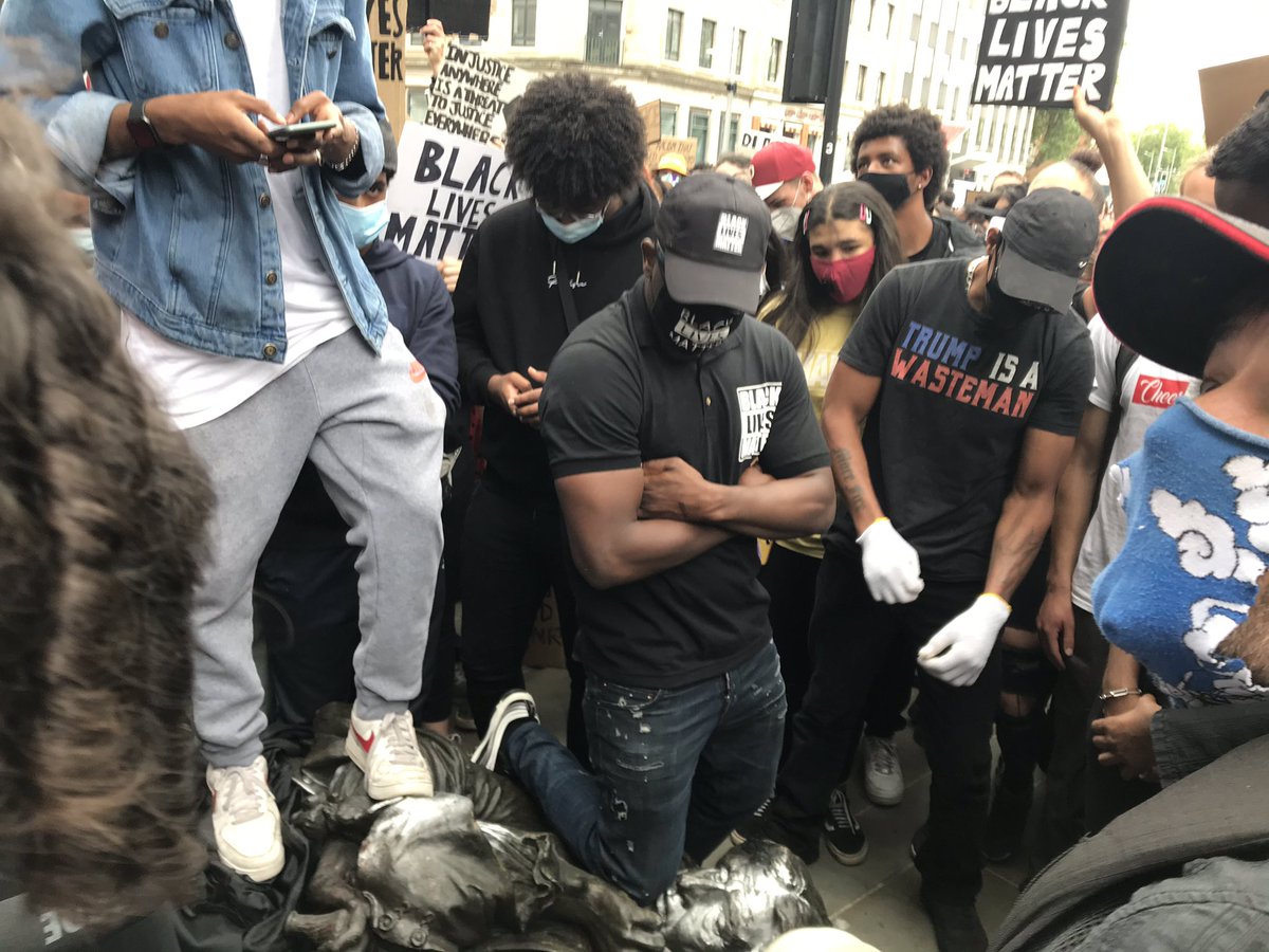 Bristol: protesters kneel on the neck of the toppled statue of Edward Colston for eight minutes