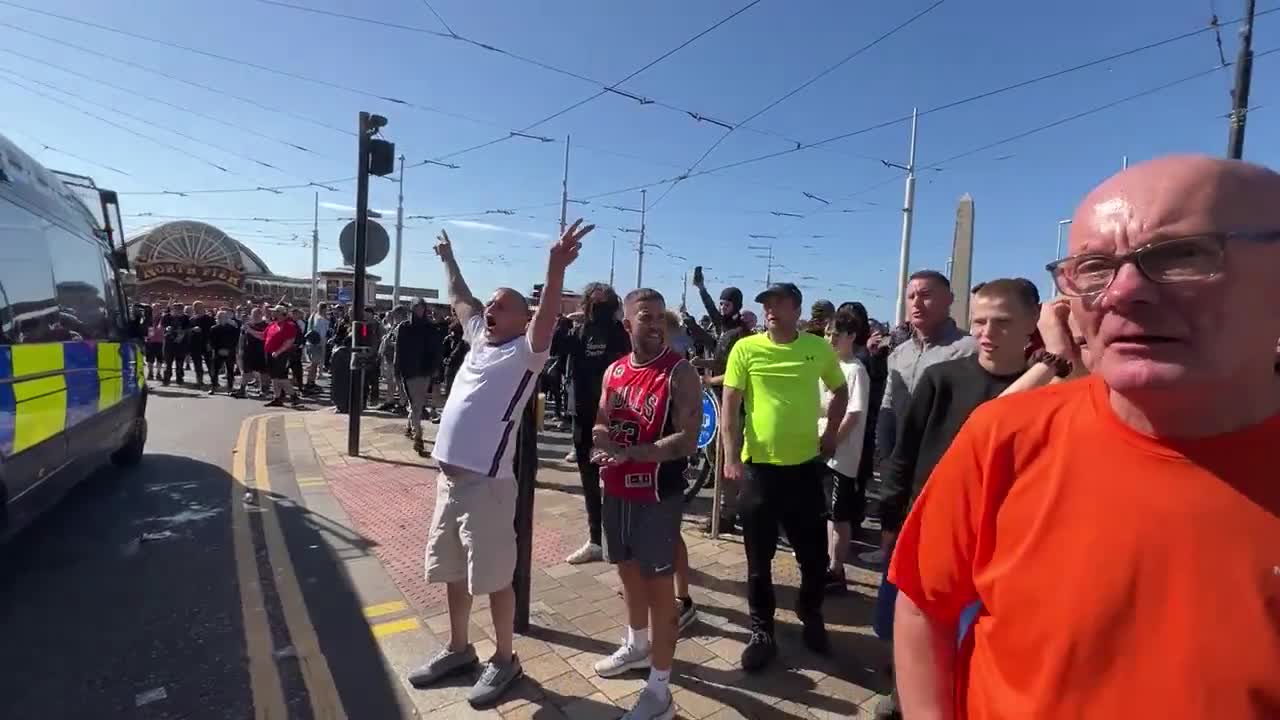 Cánticos de fútbol de los seguidores de Tommy Robinson en el mitin de Blackpool. Miembros de la multitud llaman a los policías varones nonces y difaman a las mujeres como malditas perras infértiles.