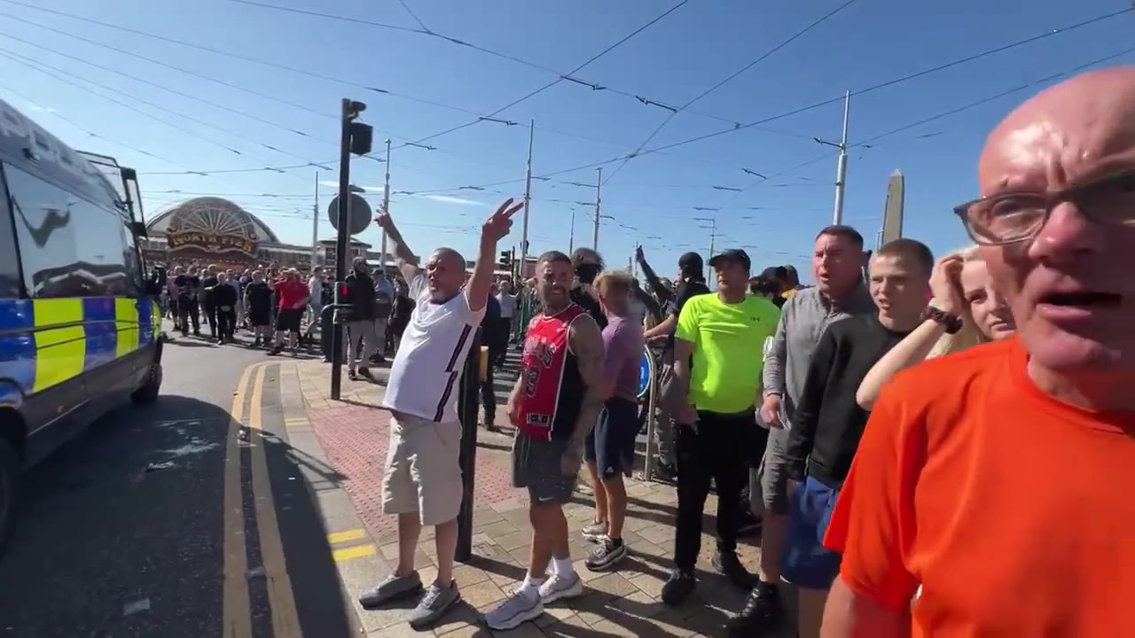 Cánticos de fútbol de los seguidores de Tommy Robinson en el mitin de Blackpool. Miembros de la multitud llaman a los policías varones nonces y difaman a las mujeres como malditas perras infértiles.