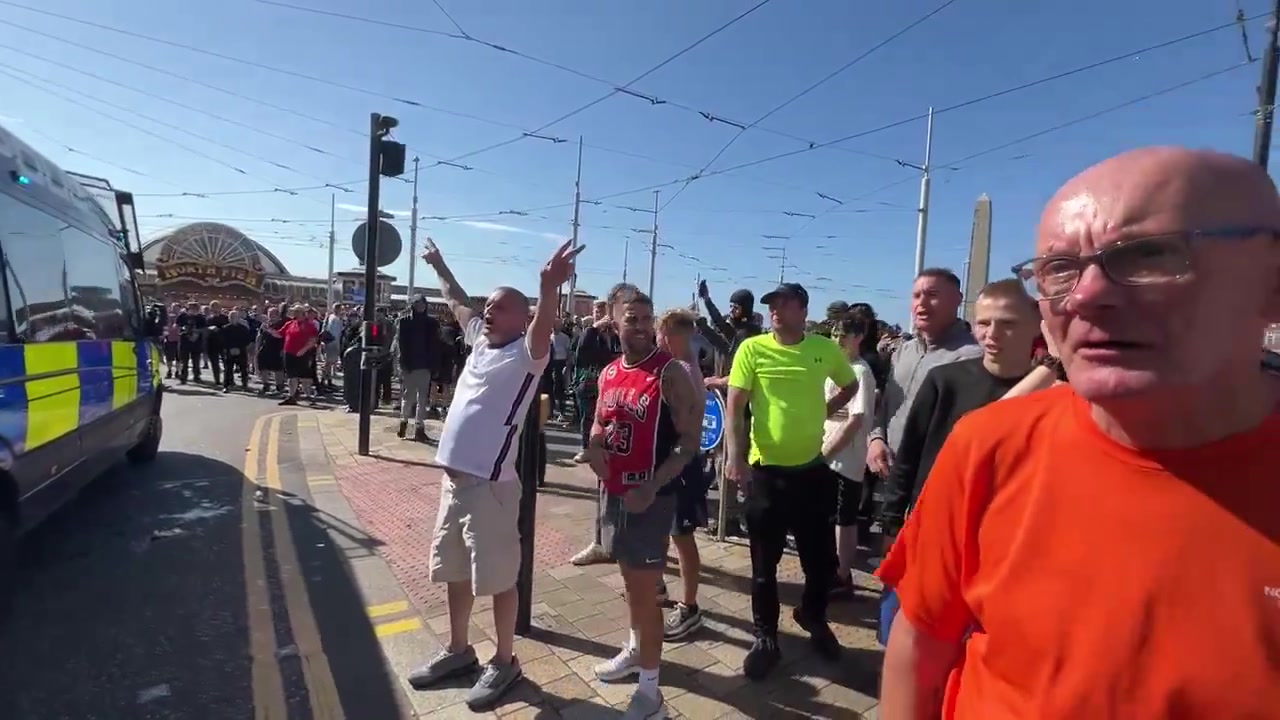 Chants de football des supporters de Tommy Robinson lors du rassemblement de Blackpool. Des membres de la foule traitent les policiers masculins de  nonces  et insultent les femmes en les qualifiant de  connards  stériles.