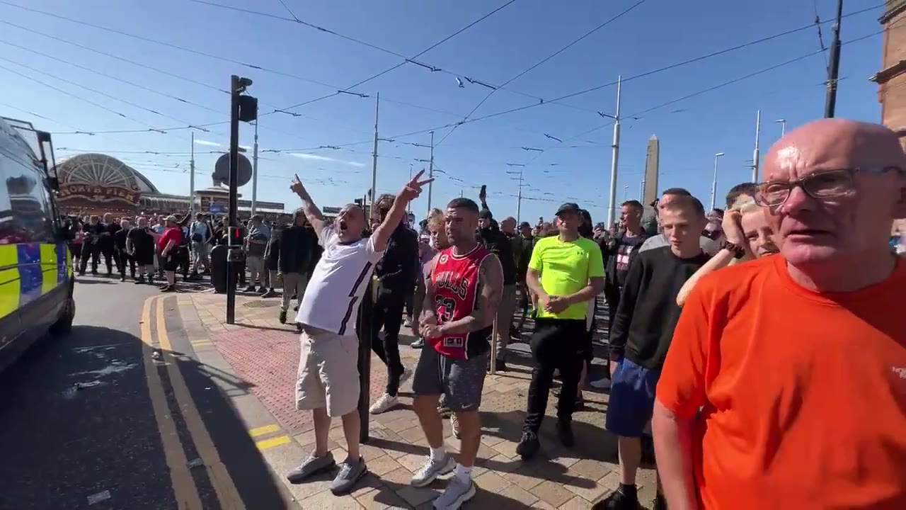 Cánticos de fútbol de los seguidores de Tommy Robinson en el mitin de Blackpool. Miembros de la multitud llaman a los policías varones nonces y difaman a las mujeres como malditas perras infértiles.