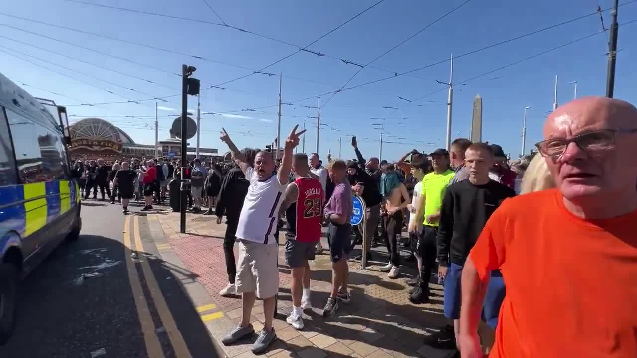 Cánticos de fútbol de los seguidores de Tommy Robinson en el mitin de Blackpool. Miembros de la multitud llaman a los policías varones nonces y difaman a las mujeres como malditas perras infértiles.